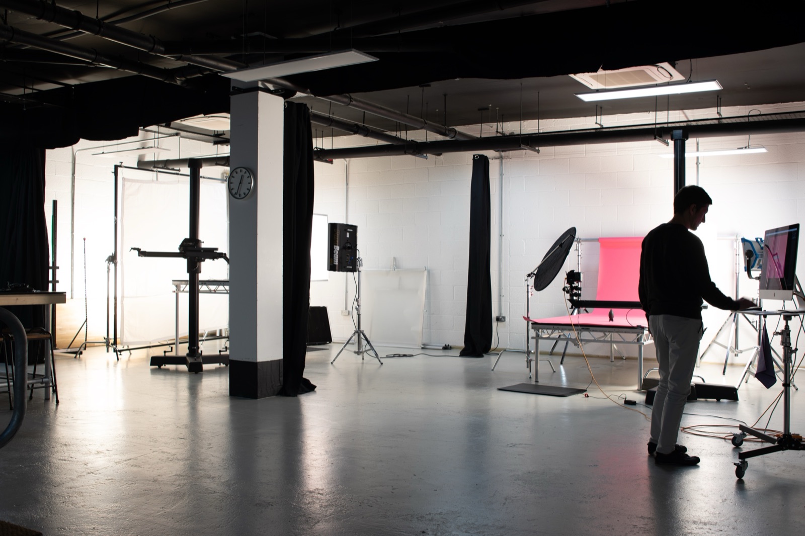 Wide shot of the Picturesmith studio during the shoot — two stages visible with lighting rigs, monitors, and the animation setup
