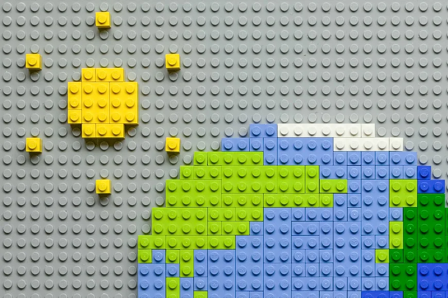 The finished brick-built frame — a mosaic of Earth in green and blue LEGO with a yellow brick sun, the central image of the World Environment Day film